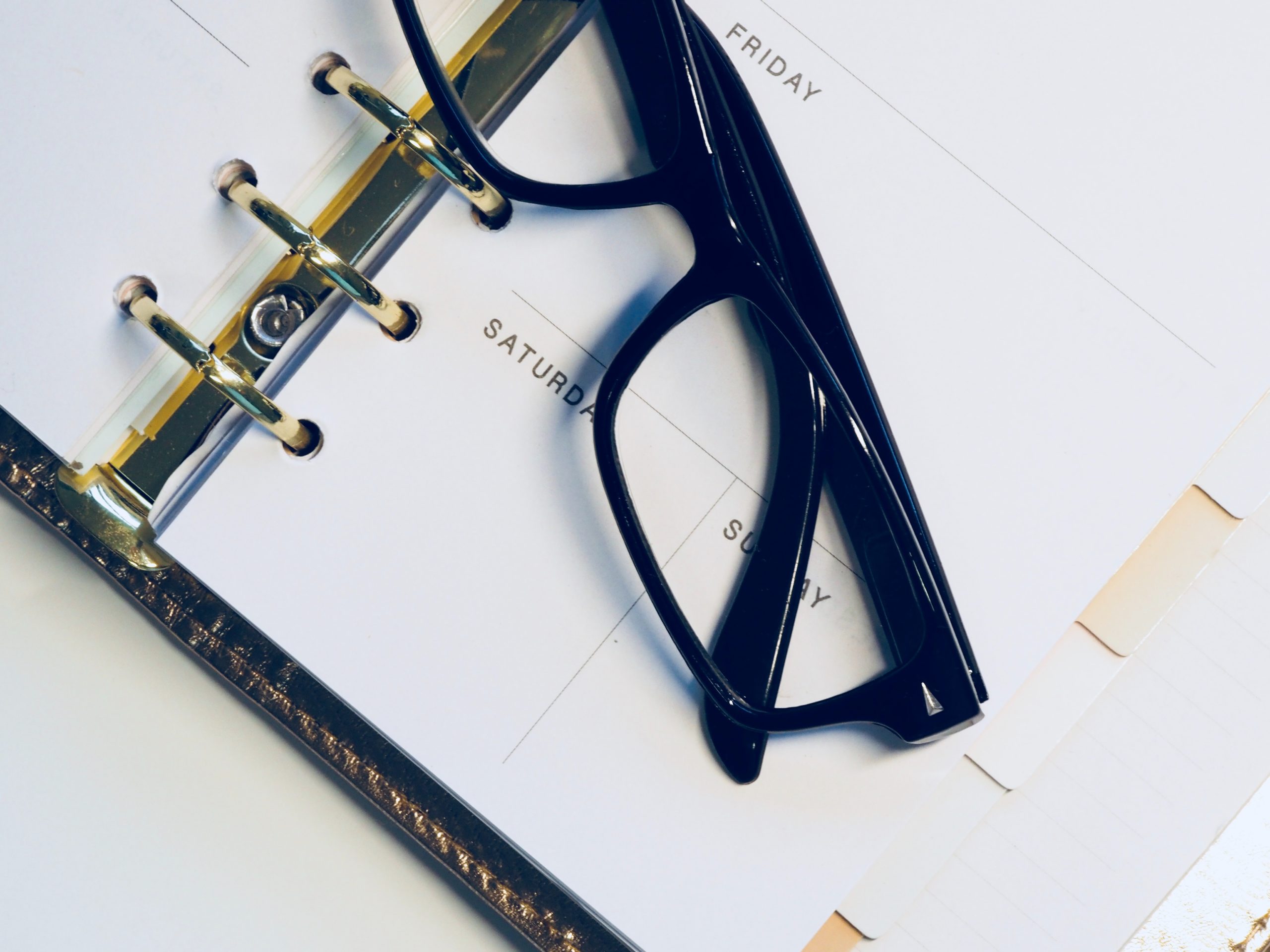 Black glasses on top of calendar book.