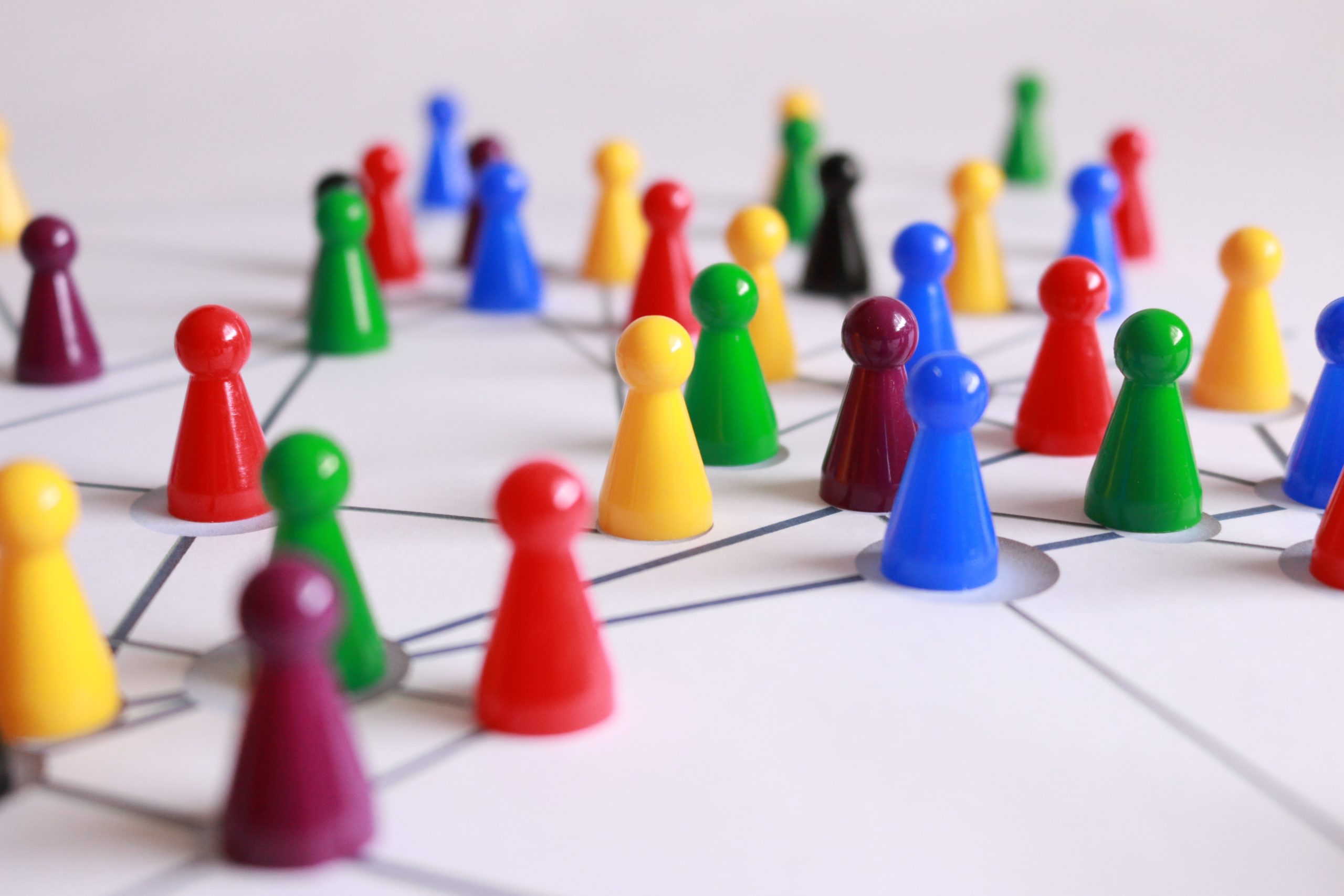 Game pawns of many colors laid out on a white surface.